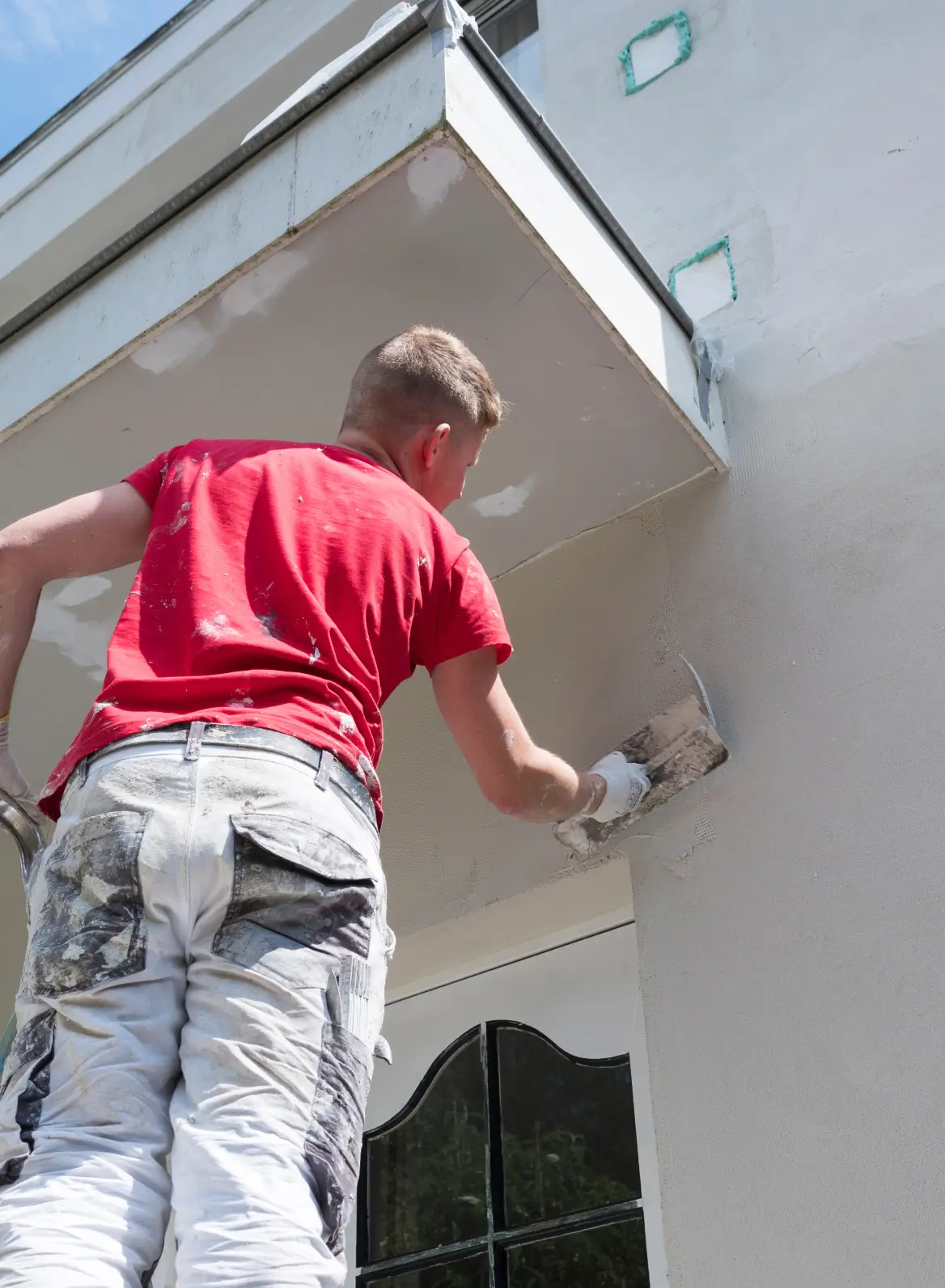 Ladder against a freshly painted exterior wall
