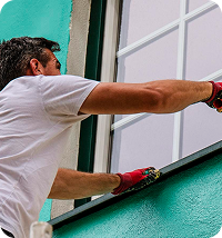 Roller applying weather-resistant coating to an exterior wall