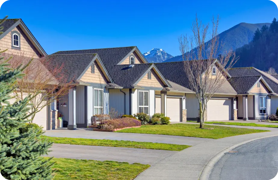 Row of townhomes with gray and white exterior paint against mountains